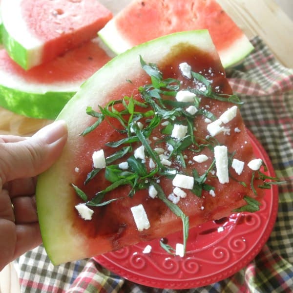 Slice of Watermelon topped with feta, basil and balsamic reduction