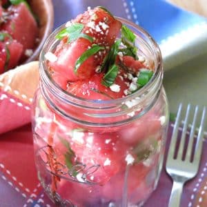 Watermelon Basil Feta Salad in a mason jar with a fork next to it.