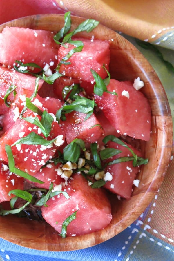 Watermelon Salad with basil, feta cheese and balsamic glaze in a bowl.