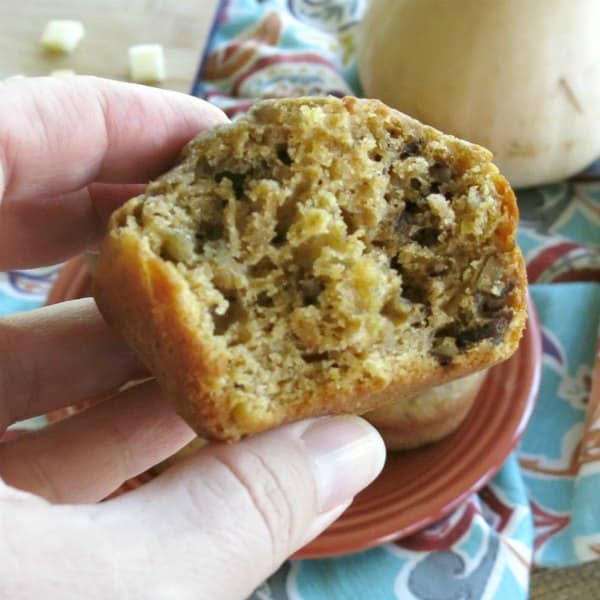 Hand holding butternut squash apple muffin with bite removed.