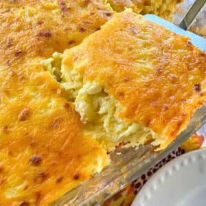 A serving of spaghetti squash au gratin being lifted out of a casserole dish.