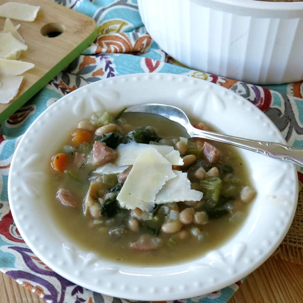 Bowl of sausage white bean soup with Parmesan cheese on top