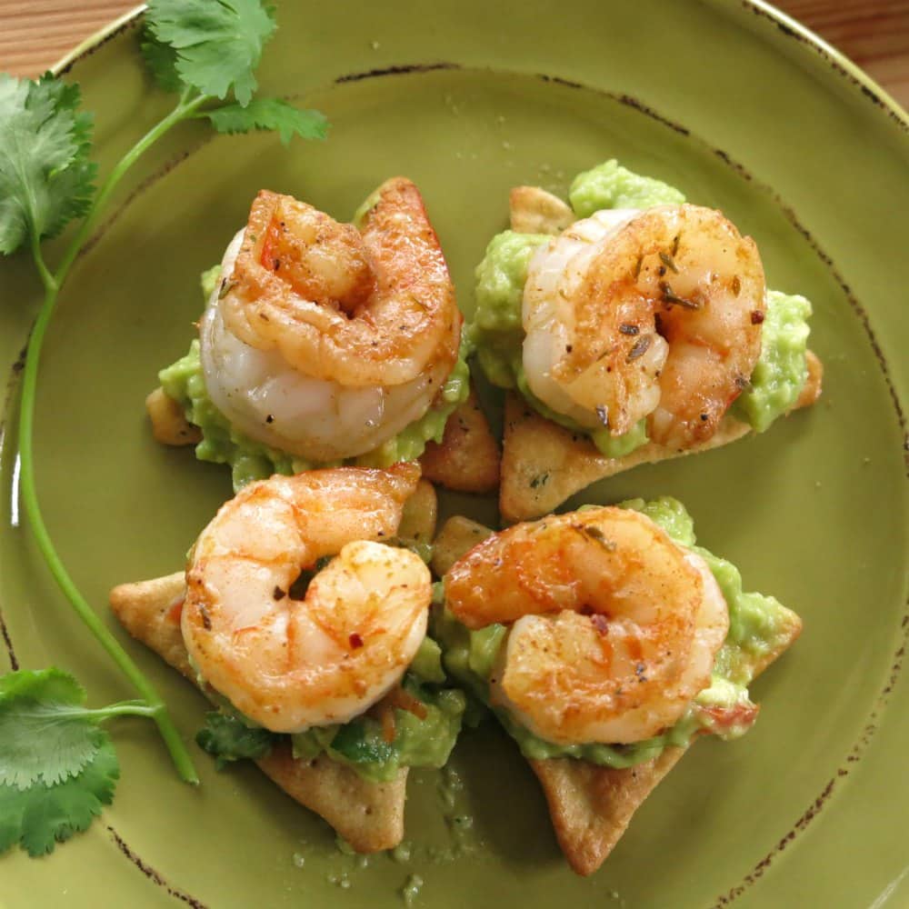 4 pieces of shrimp and guacamole appetizer on plate.