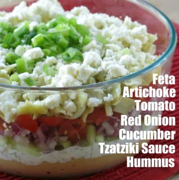 Greek Layer Dip in glass bowl with layers labeled.