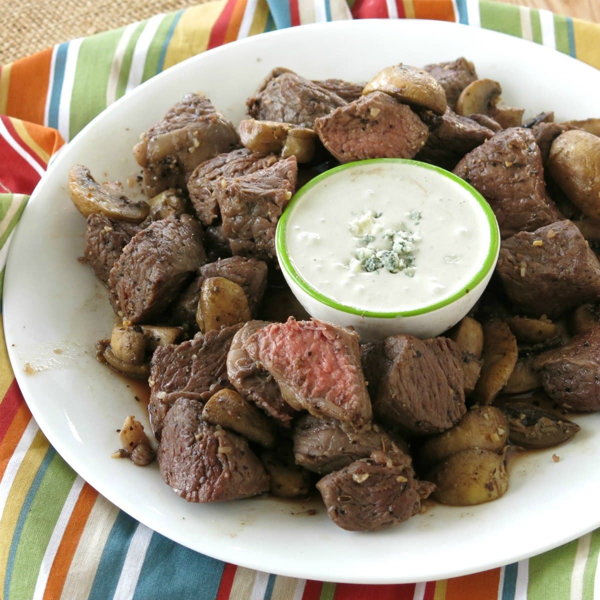 Air Fryer Steak Bites on a plate with mushrooms and blue cheese dipping sauce.