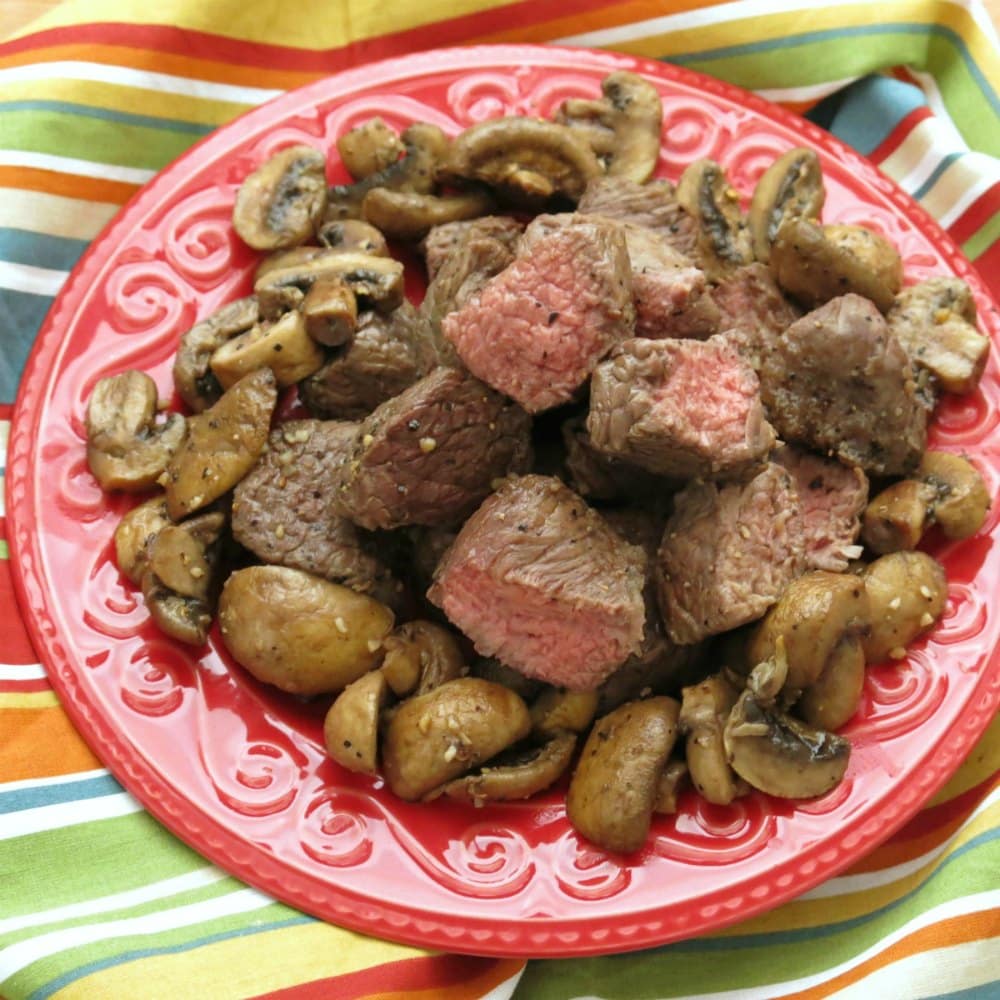 Sirloin steak and mushrooms cooked in an air fryer on a plate,
