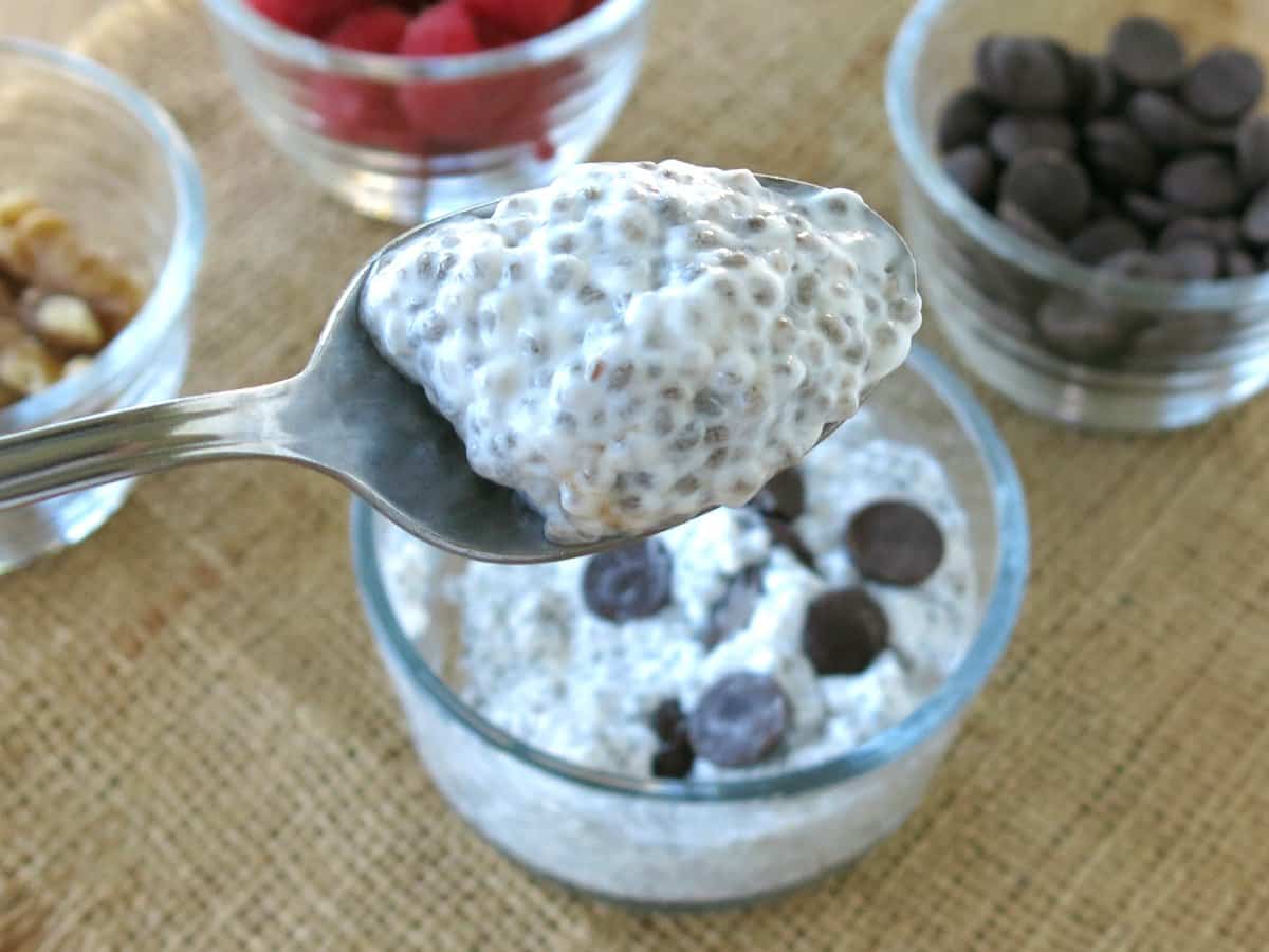 Low-carb Chia seed pudding on a spoon with bowl below it.