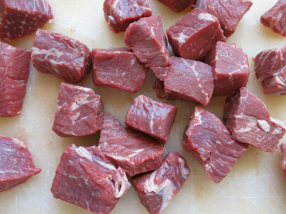 Cubed sirloin steak filets on a cutting board.