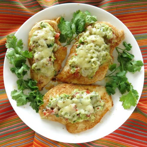Guacamole chicken melts on a plate surrounded by cilantro