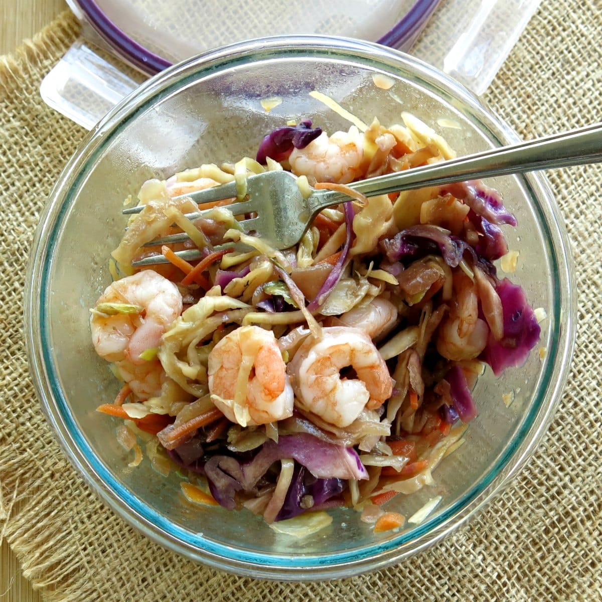 Shrimp egg roll bowl in meal prep container next to lid.