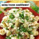Mexican street cauliflower with lime crema, Cotija, and chopped cilantro on a red dish.