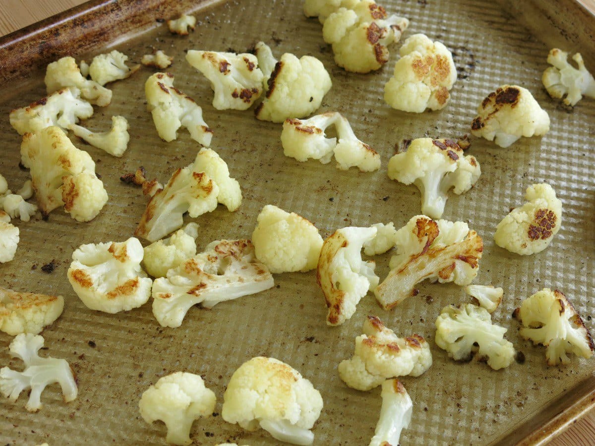 Roasted cauliflower florets on a sheet pan.