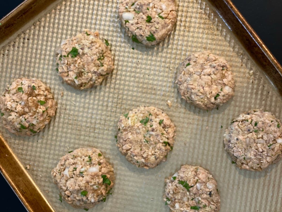 Uncooked salmon patties on baking sheet.