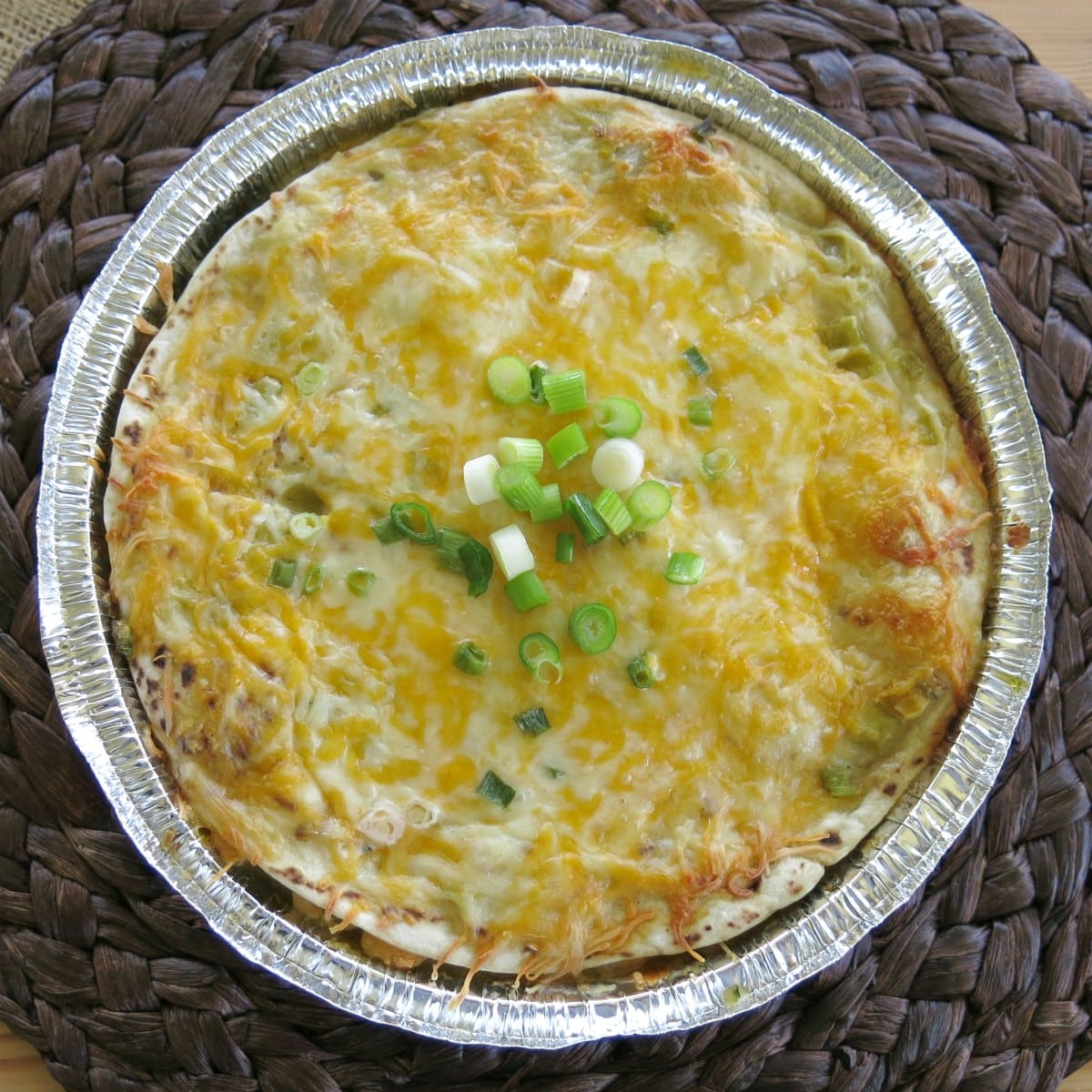 Cooked chicken enchilada pie in a round pan.