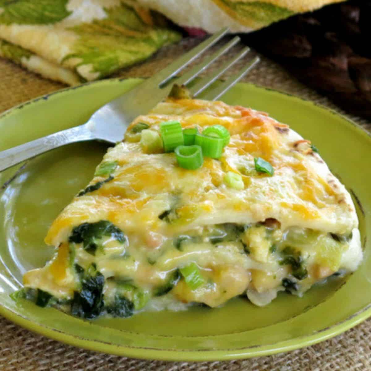 Slice of Chicken Enchilada Pie Casserole on a plate with a fork.