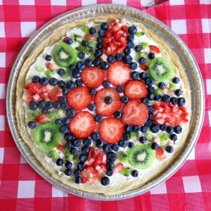 Color pizza cookie topped with kiwi, strawberries and blueberries.