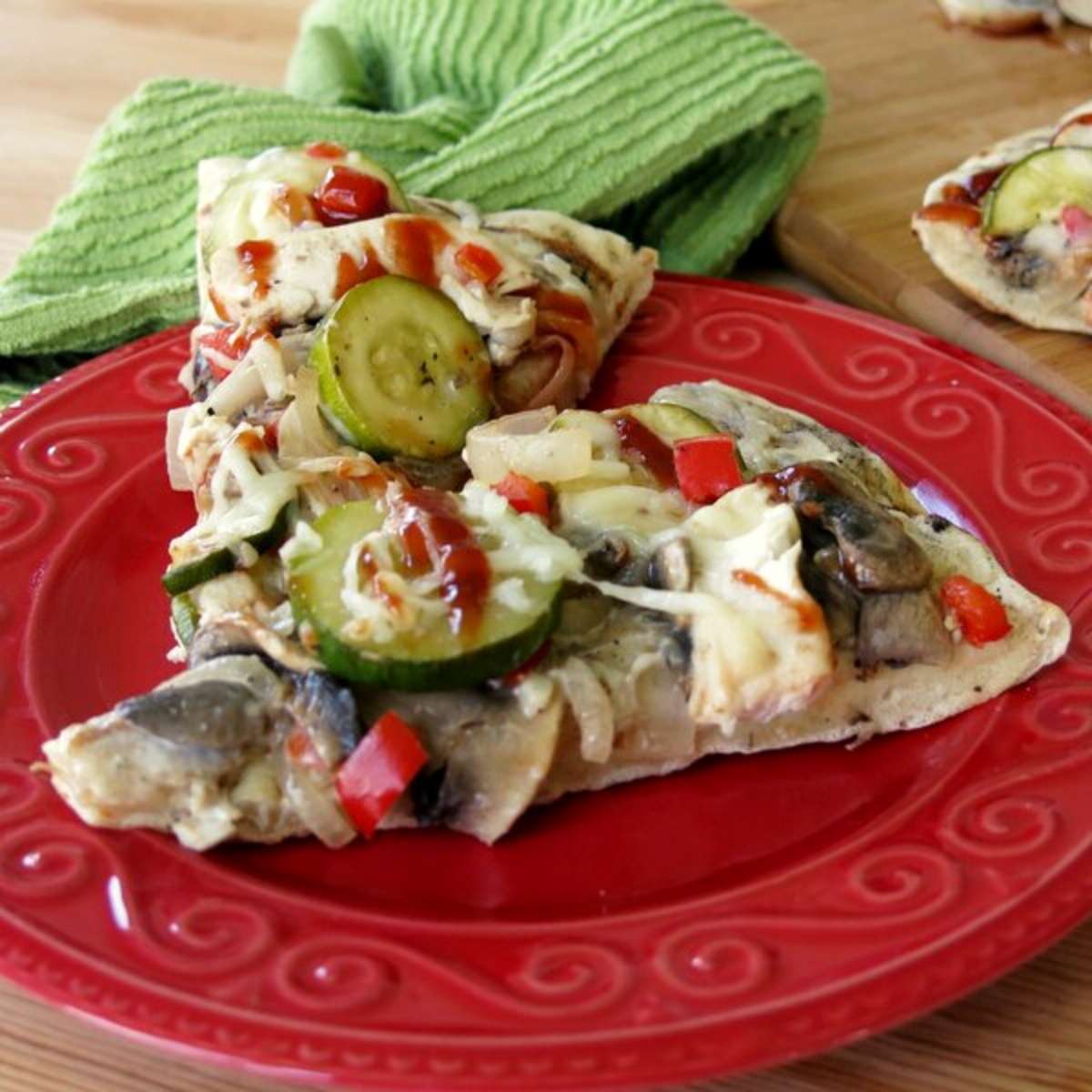 2 slices of Grilled BBQ Chicken Pizza with Veggies on a plate.