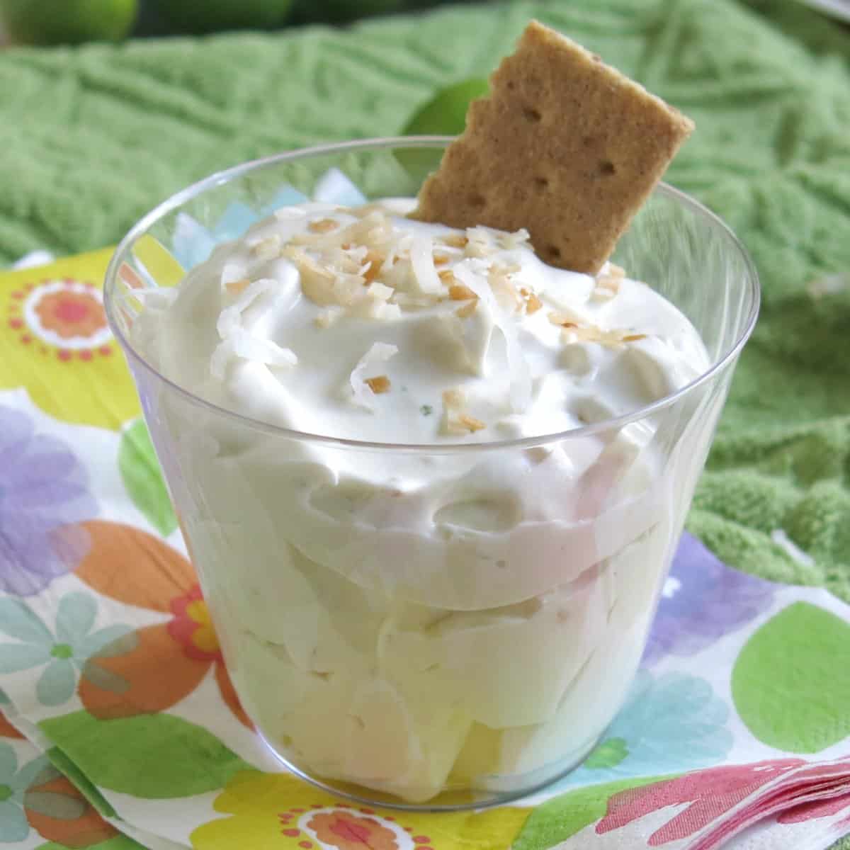 Key Lime Pie Dip Recipe in a cup with graham cracker dipped in one side.