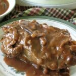 Slow Cooker Beef Shoulder Roast covered with red wine mushroom sauce on a plate.