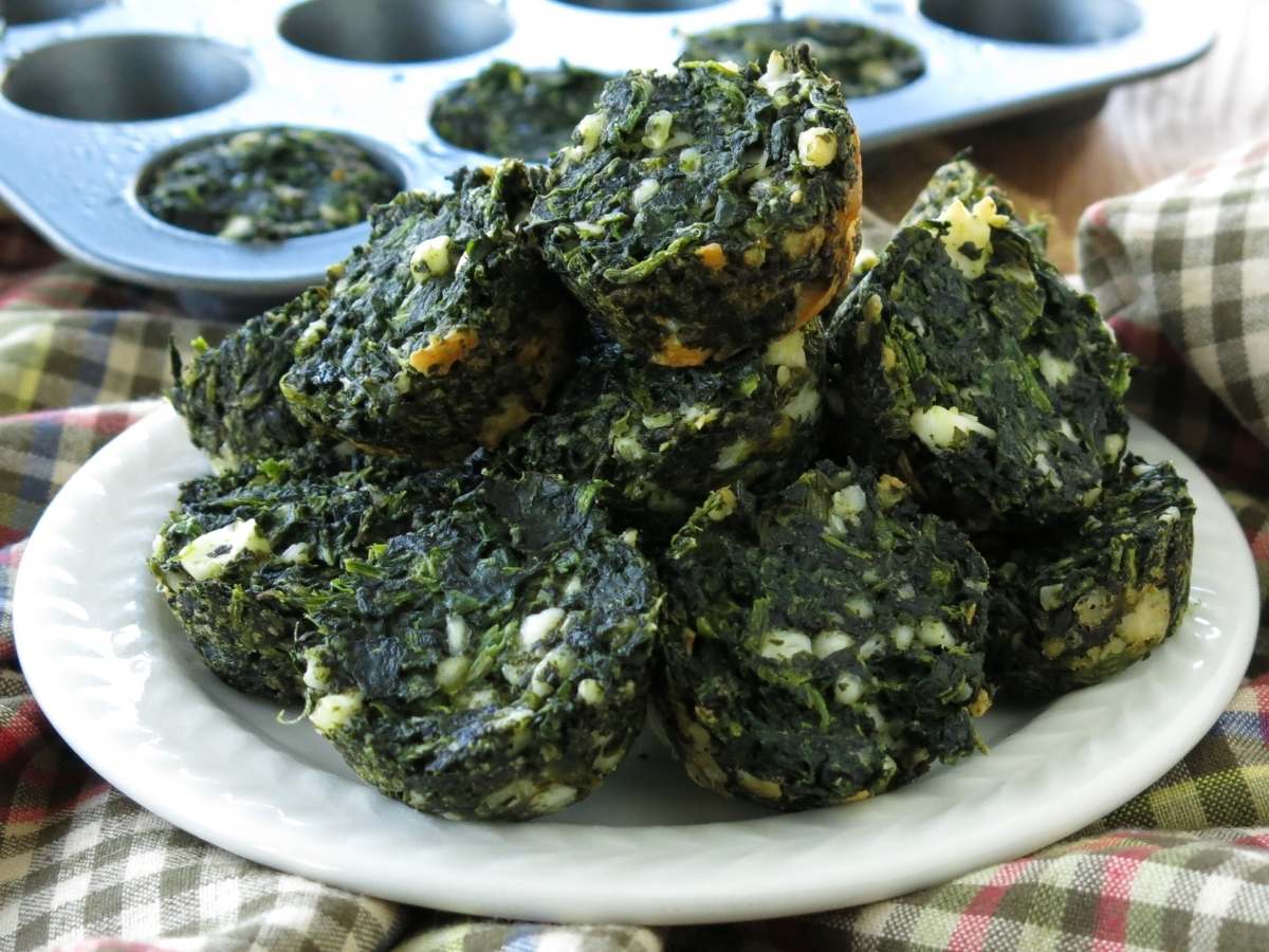 Plate of keto spinach feta egg muffins with a mini muffin pan in background.