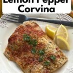 Baked lemon pepper corvina fish fillet on a plate.