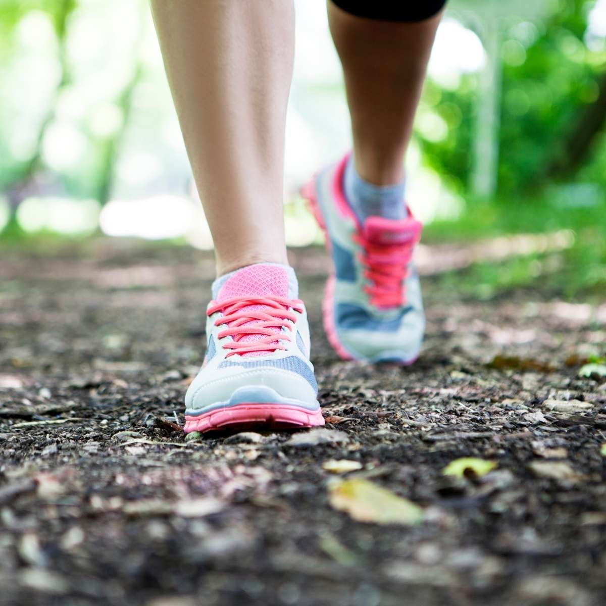 Picture of person's shins and feet walking in tennis shoes.