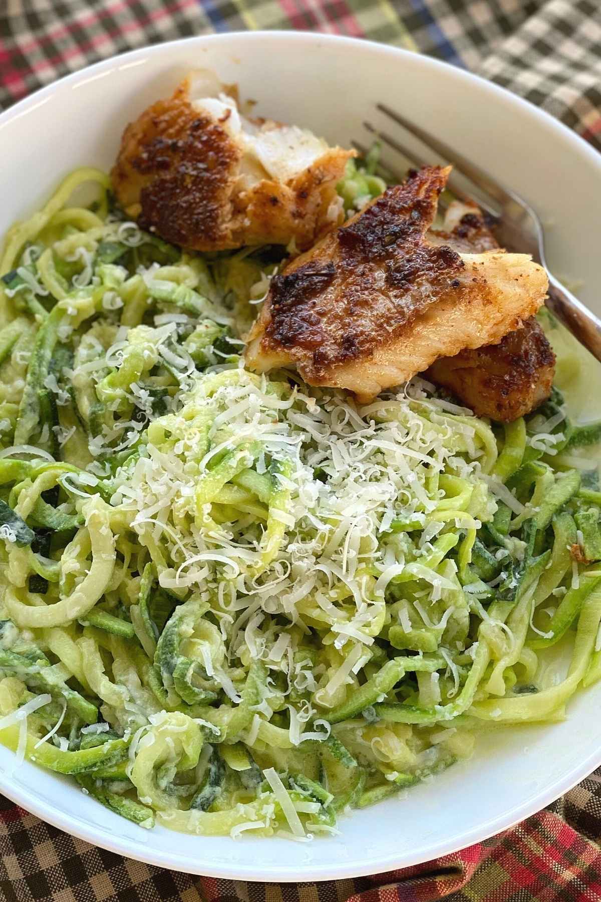 Fish with zucchini noodle alfredo in a bowl.