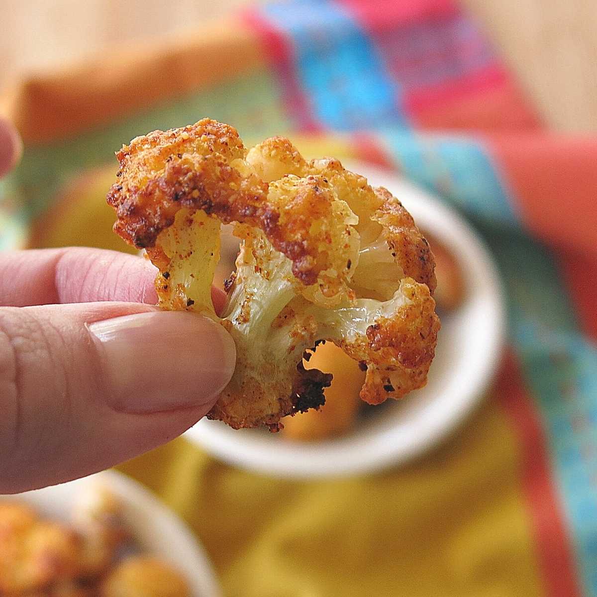 Parmesan Cauliflower Appetizer being held by two fingers.