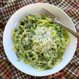 Bowl of zucchini noodle alfredo with a fork.