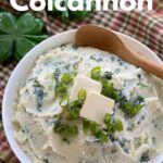 Bowl of Mashed Cauliflower Colcannon with shamrocks in the background.