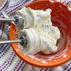 Beaters from a mixer with cream cheese on it.