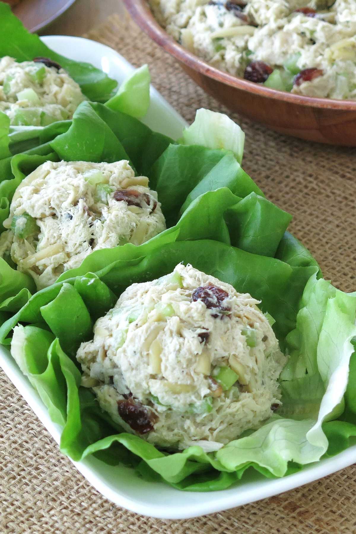 Scoops of crock-pot chicken salad on lettuce leaves on a platter.