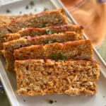 Slices of ground chicken meatloaf on a platter.