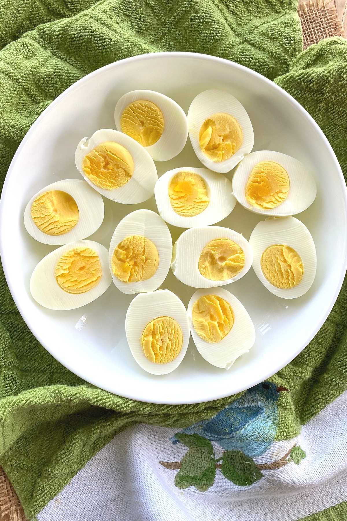 Plate of hard boiled egg halves on a towel.