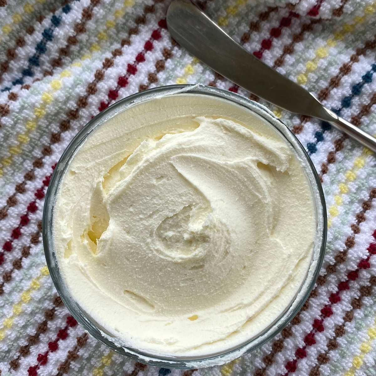 Bowl of previously frozen cream cheese that has been whipped until creamy.