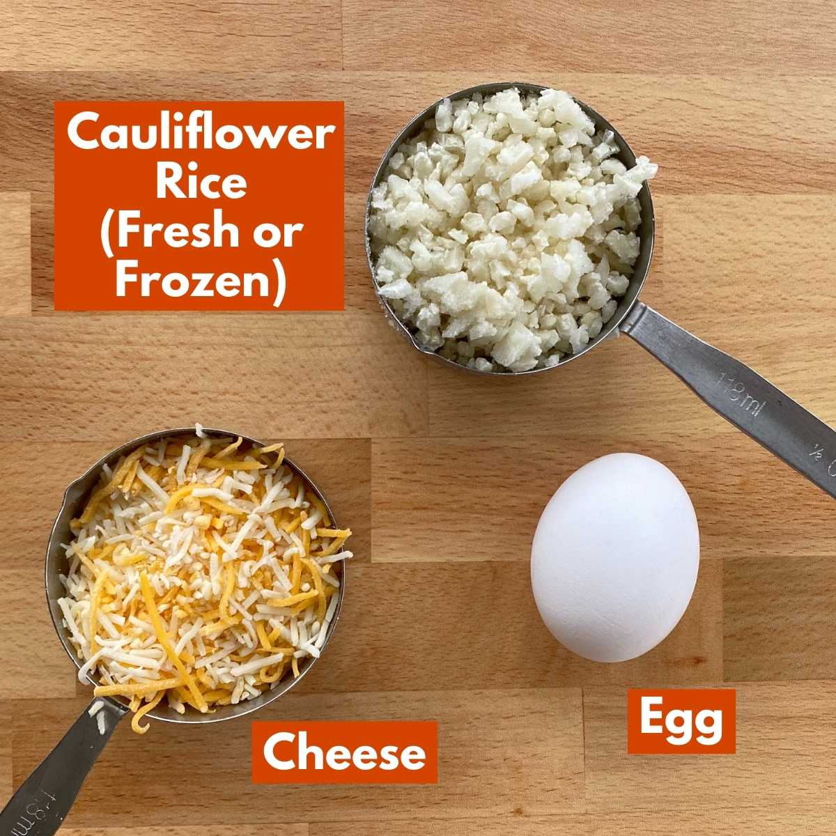 Ingredients to make recipe: cauliflower rice, egg and shredded cheese on cutting board.