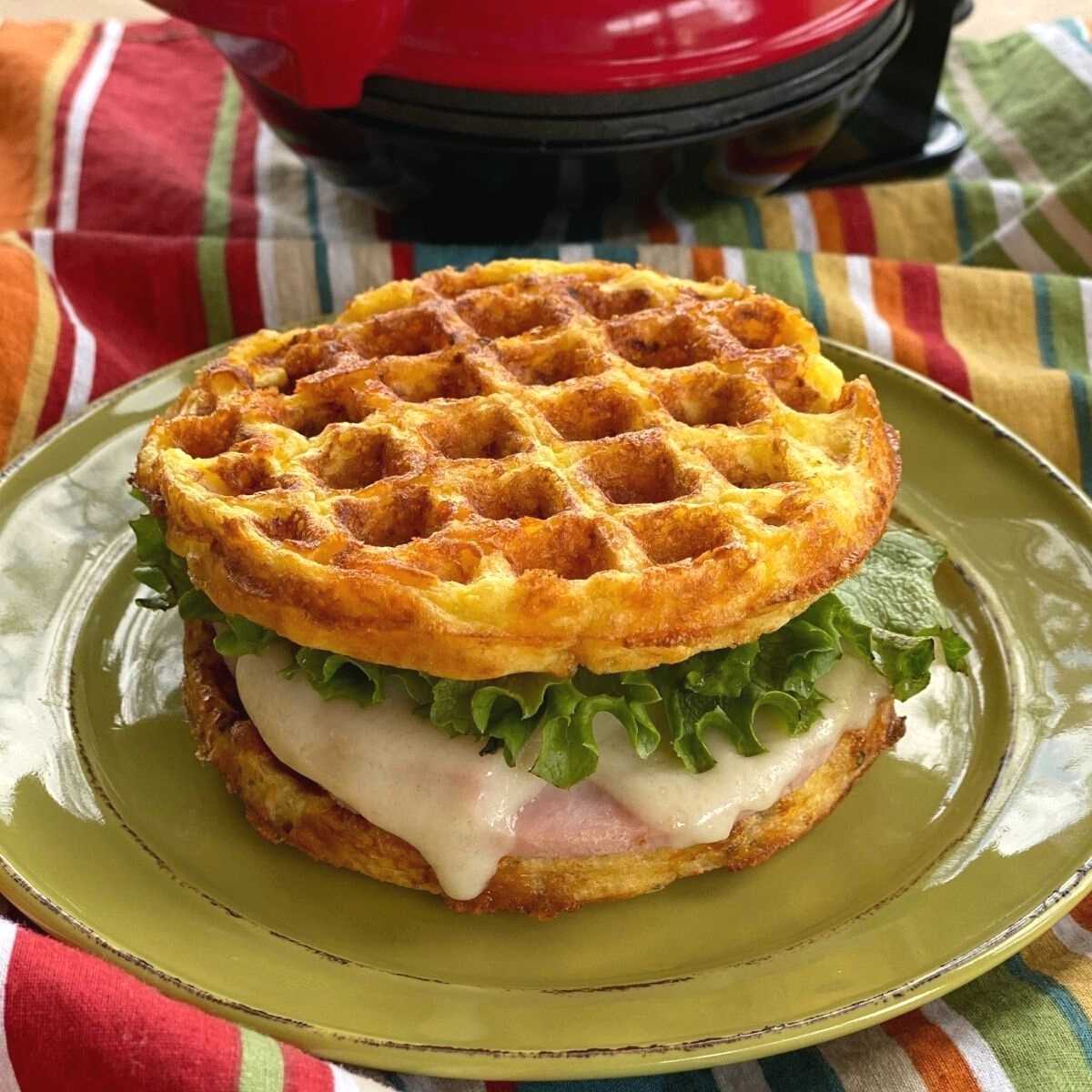 Ham and cheese sandwich with chaffle bread on the top and bottom.