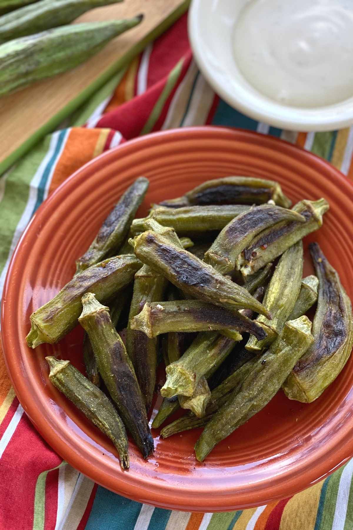 Whole Okra Fries on plate with ranch dressing behind it.