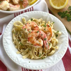 Red Argentine Shrimp Scampi over a bowl of pasta.