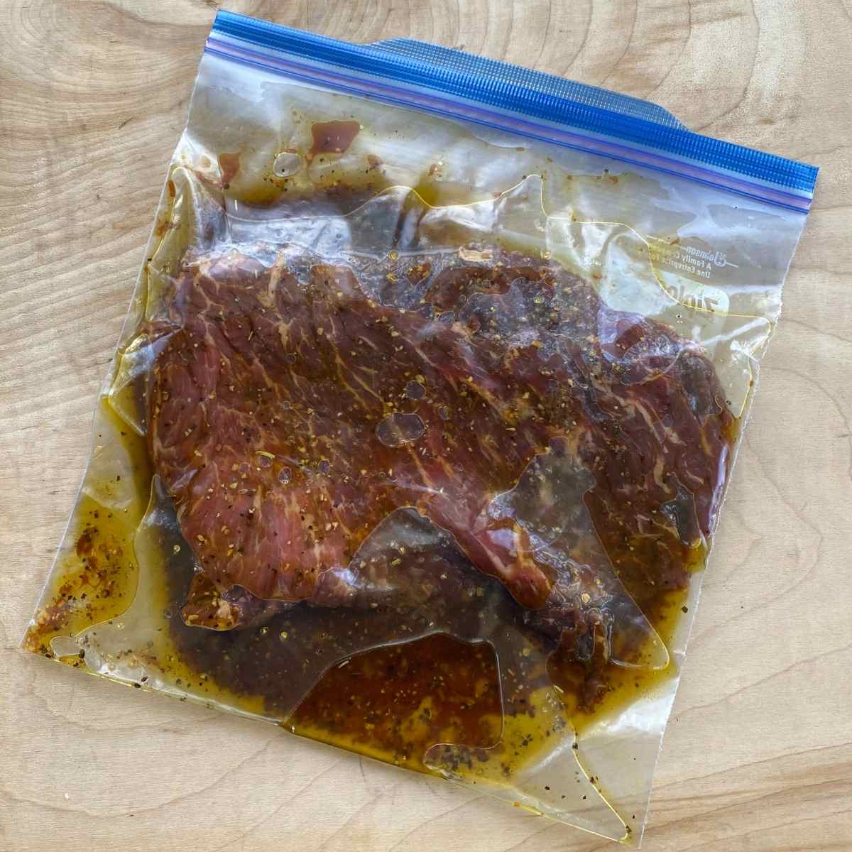 Bavette steak meat marinating in a plastic bag.