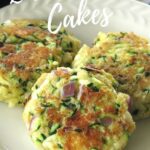 Three zucchini cakes on plate with title above it.