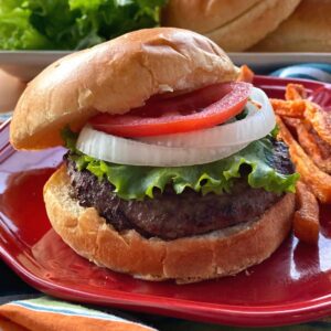 Wagu Beef Burger on a brioche bun topped with lettuce, onion, and tomato.