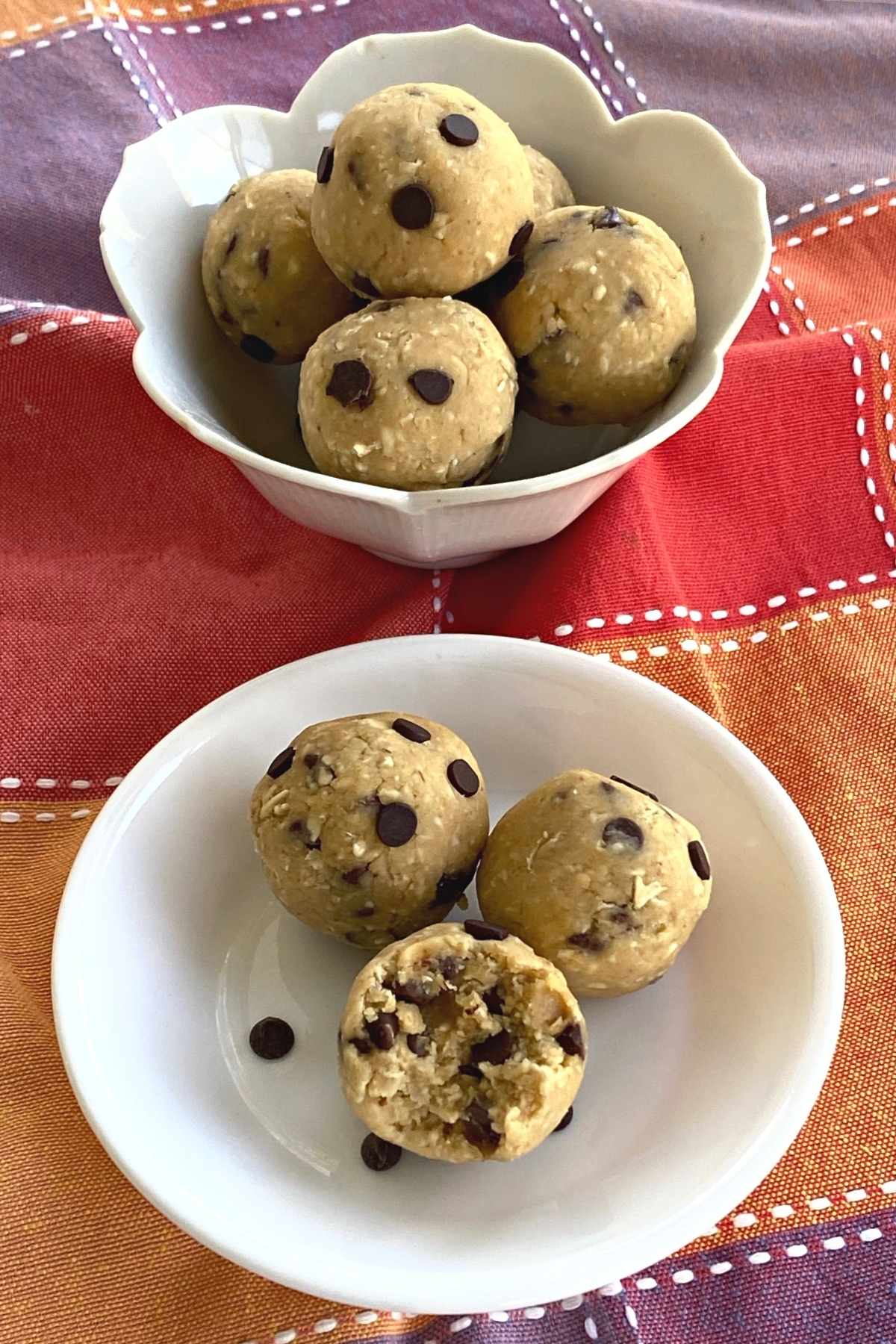 Chickpea cookie dough bites on plate and in a bowl with bite taken out of one.