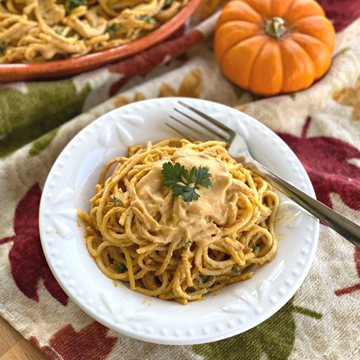 Bowl with creamy pumpkin pasta sauce over spaghetti noodles.