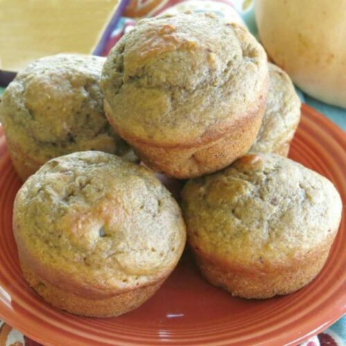 Butternut squash muffins with apple stacked on a plate.