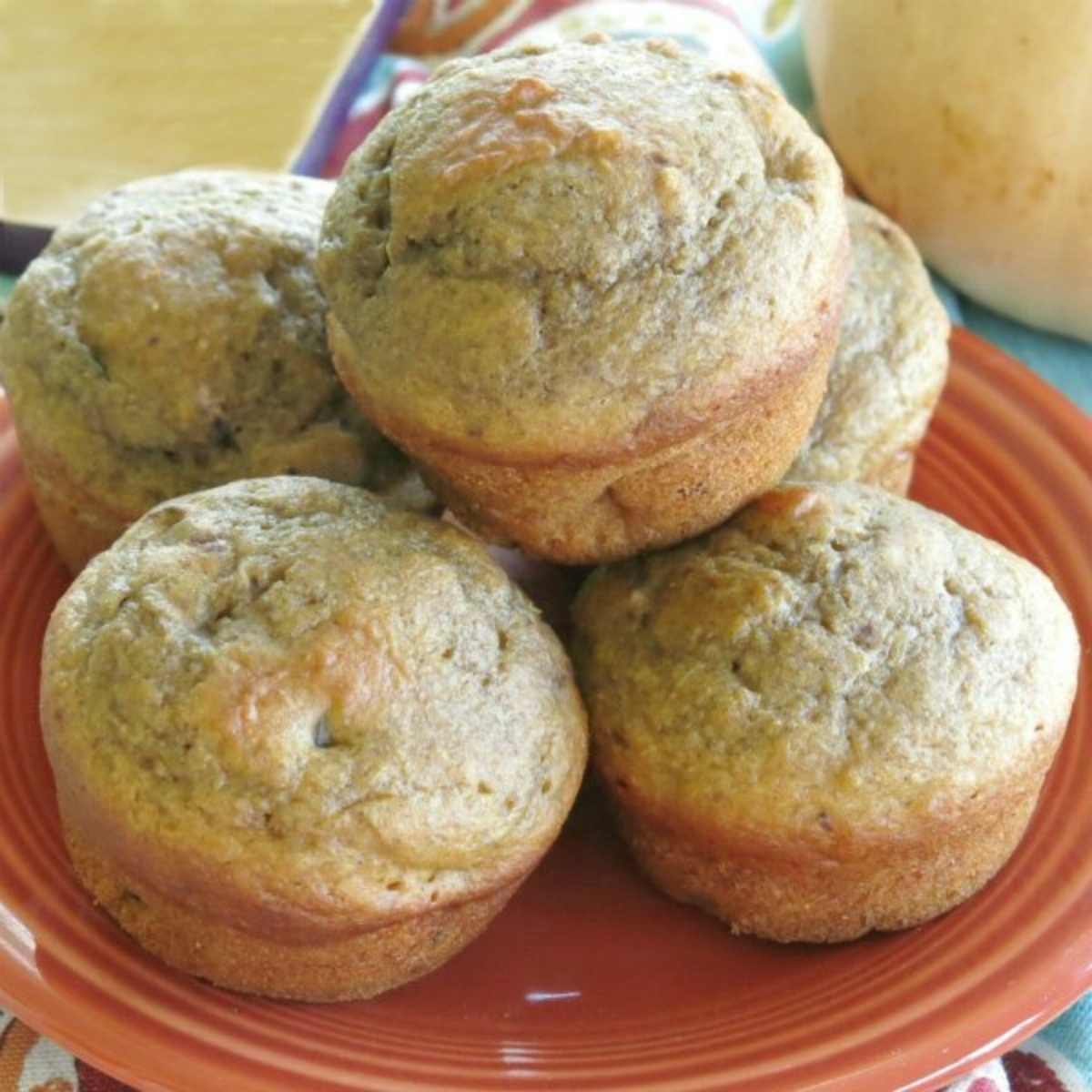 Healthy butternut squash muffins with apple stacked on a plate.