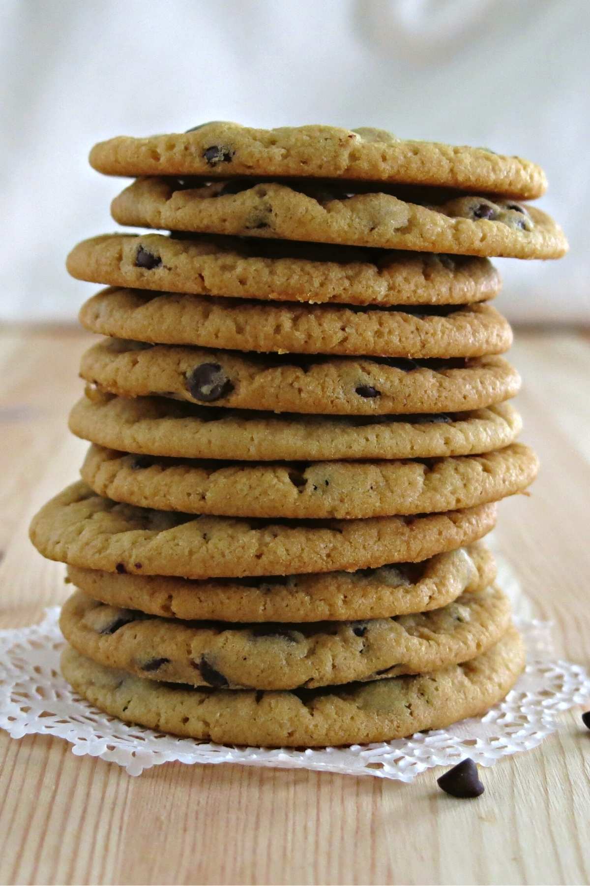 Stack of eleven chocolate chips cookies make without egg on a plate.