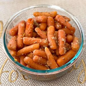 Garlic sauteed baby carrots in a serving dish.