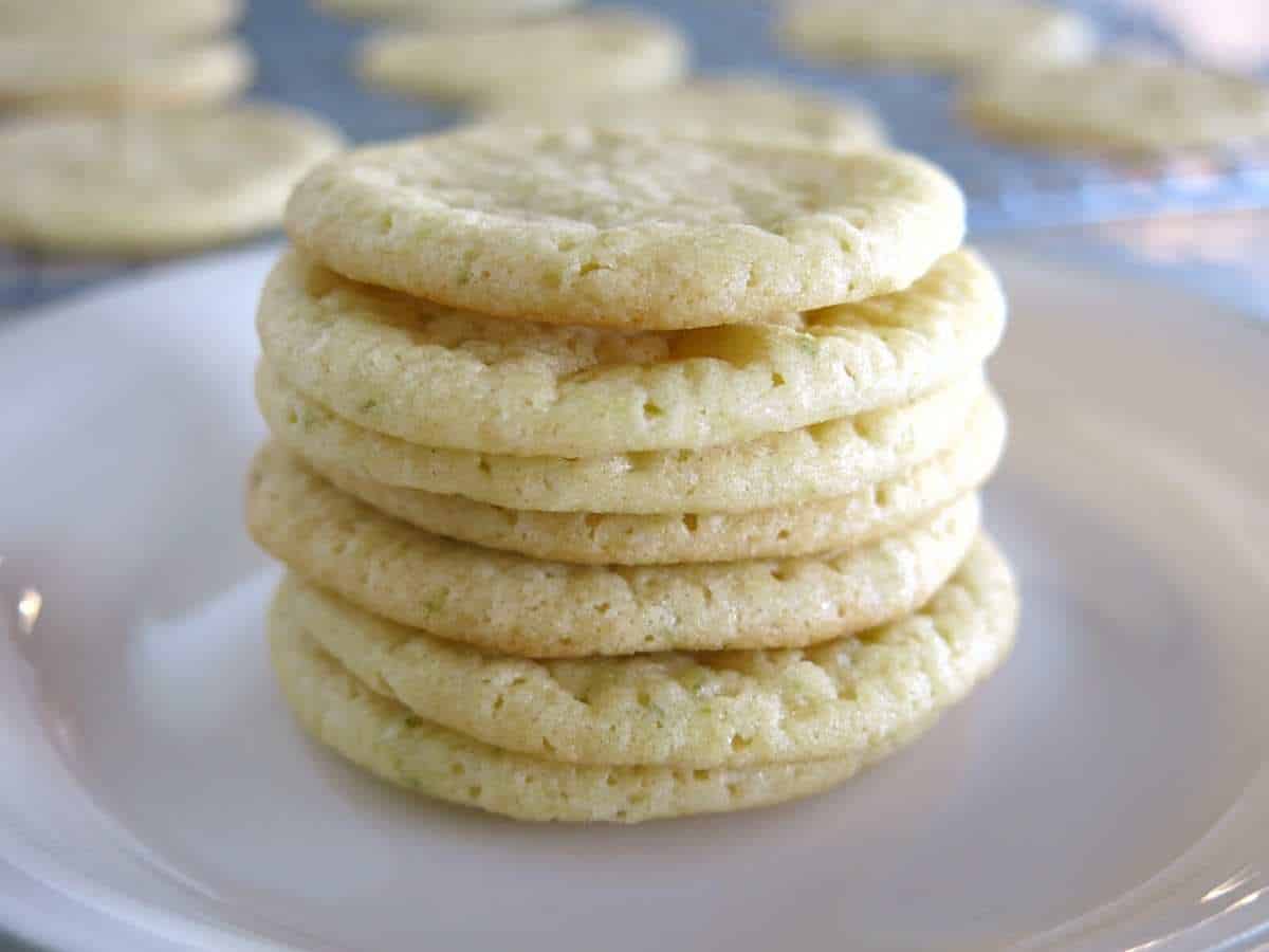 Key lime sugar cookies stacked on a plate.