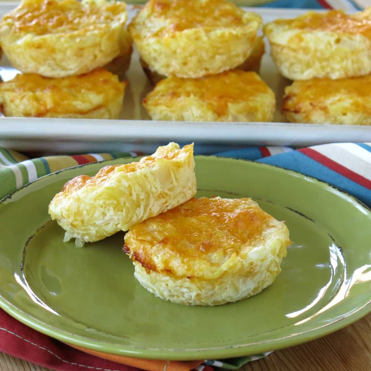 Two spaghetti squash au gratin mini casserole cups with a platter of more behind them.